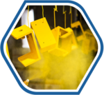 Industrial components being sprayed with yellow paint, representing the precision and quality involved in the production process of industrial raw material supplies.