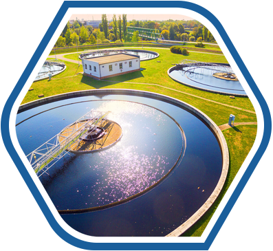 An aerial view of a water treatment facility with large circular tanks, highlighting the importance of clean and purified water in the manufacturing process of Raw Material Supplies.